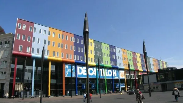 Kleurrijk gebouw aan de Johan Cruijff Boulevard in Amsterdam met de Decathlon-winkel op de begane grond.